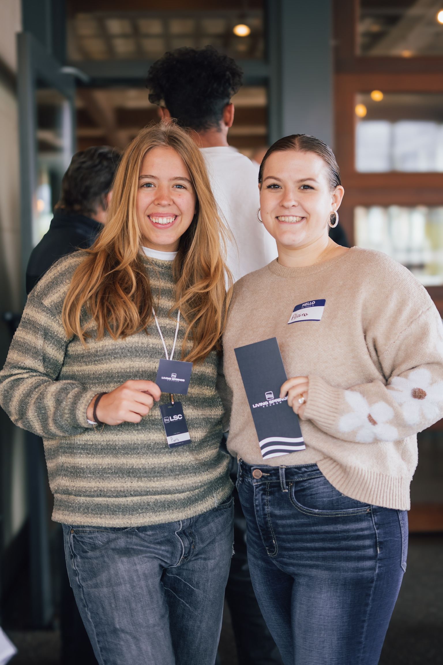 Two greeters wearing Here to Serve badges
