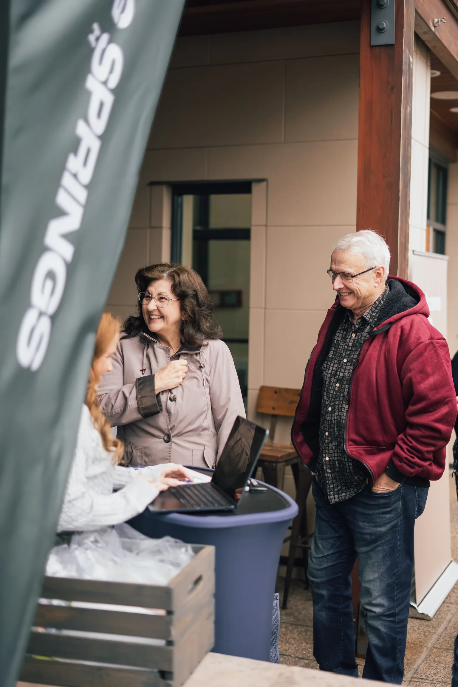 A couple welcomed at an outdoor information table