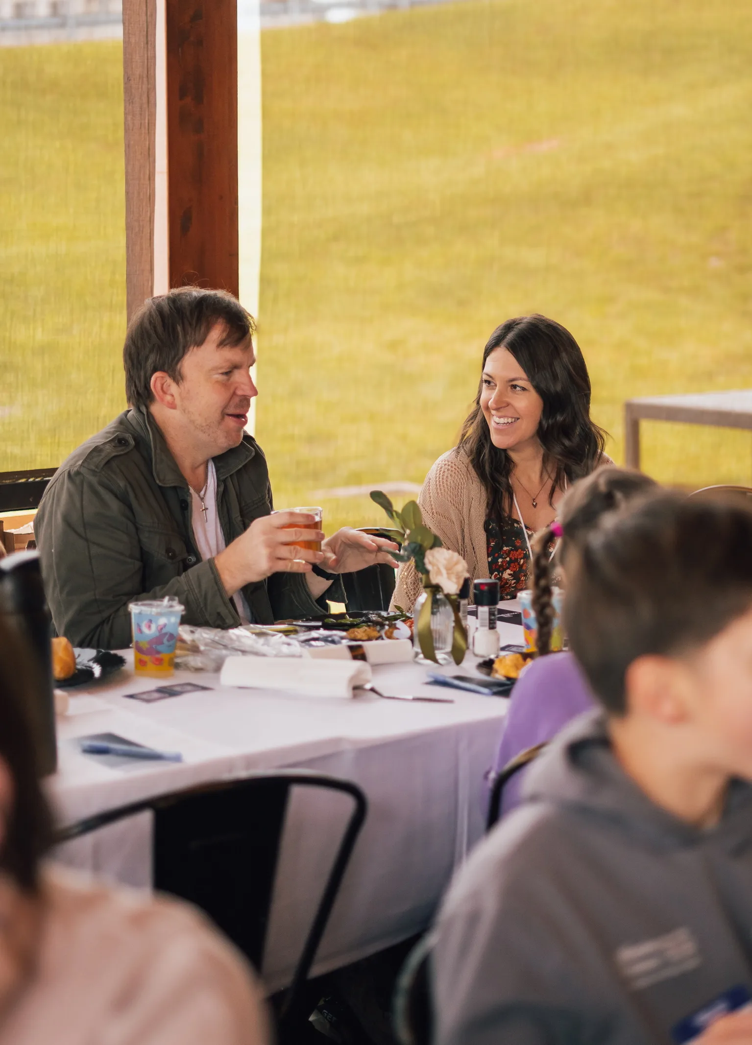 Adults talking and laughing around an outdoor table