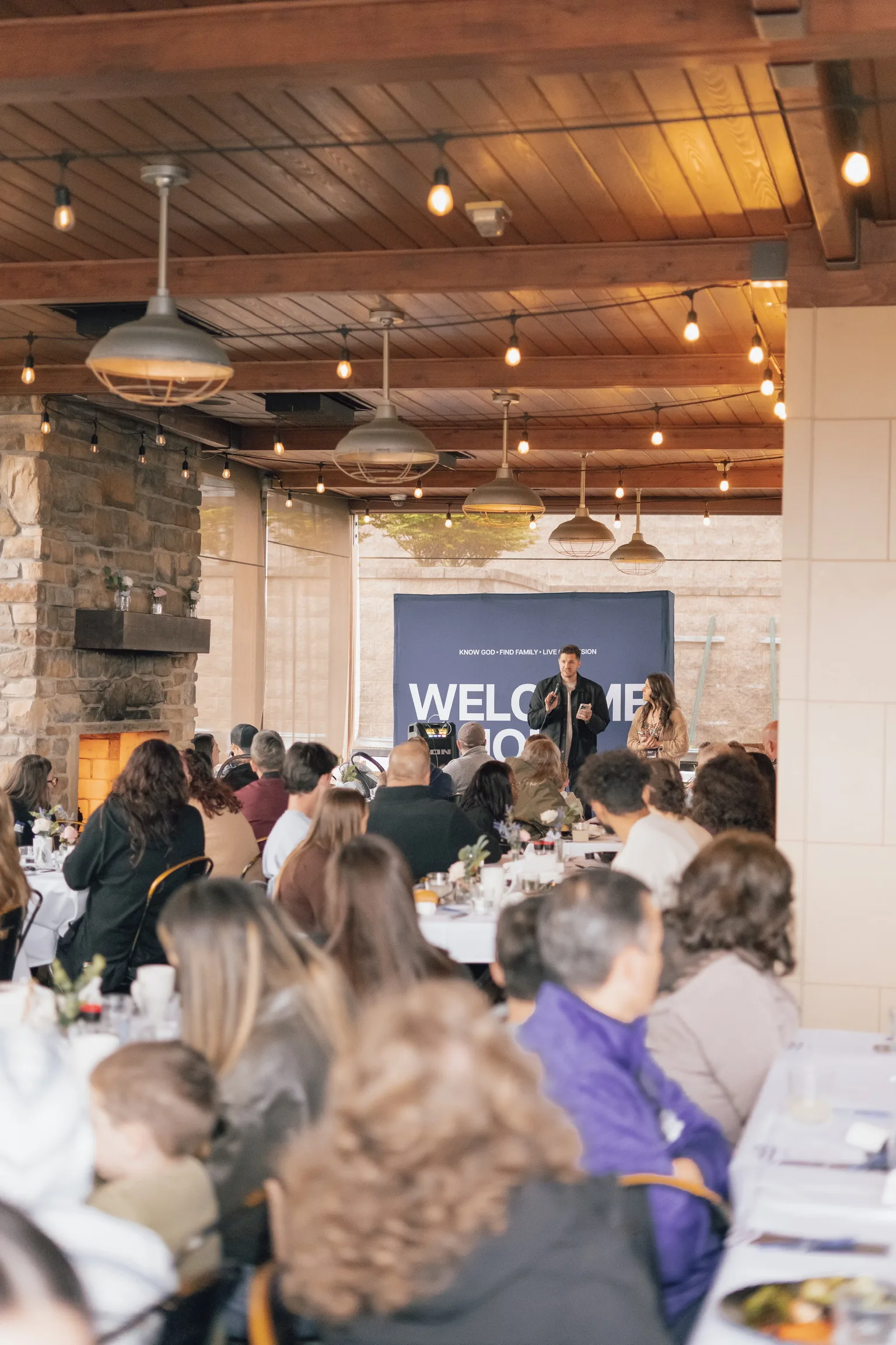 Pastors and friends gathered under the Welcome backdrop at Living Springs