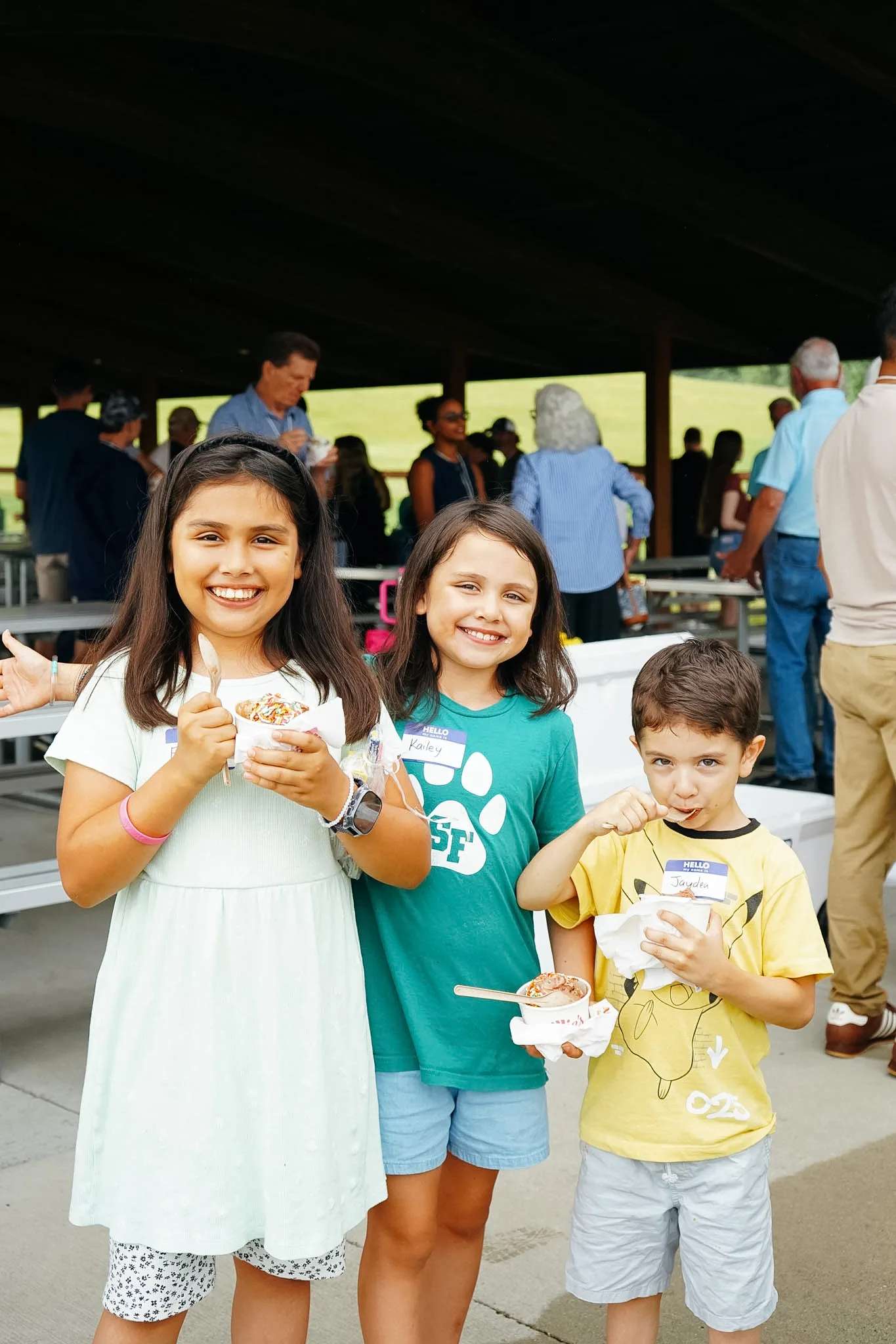 Three kids holding snacks at a church gathering