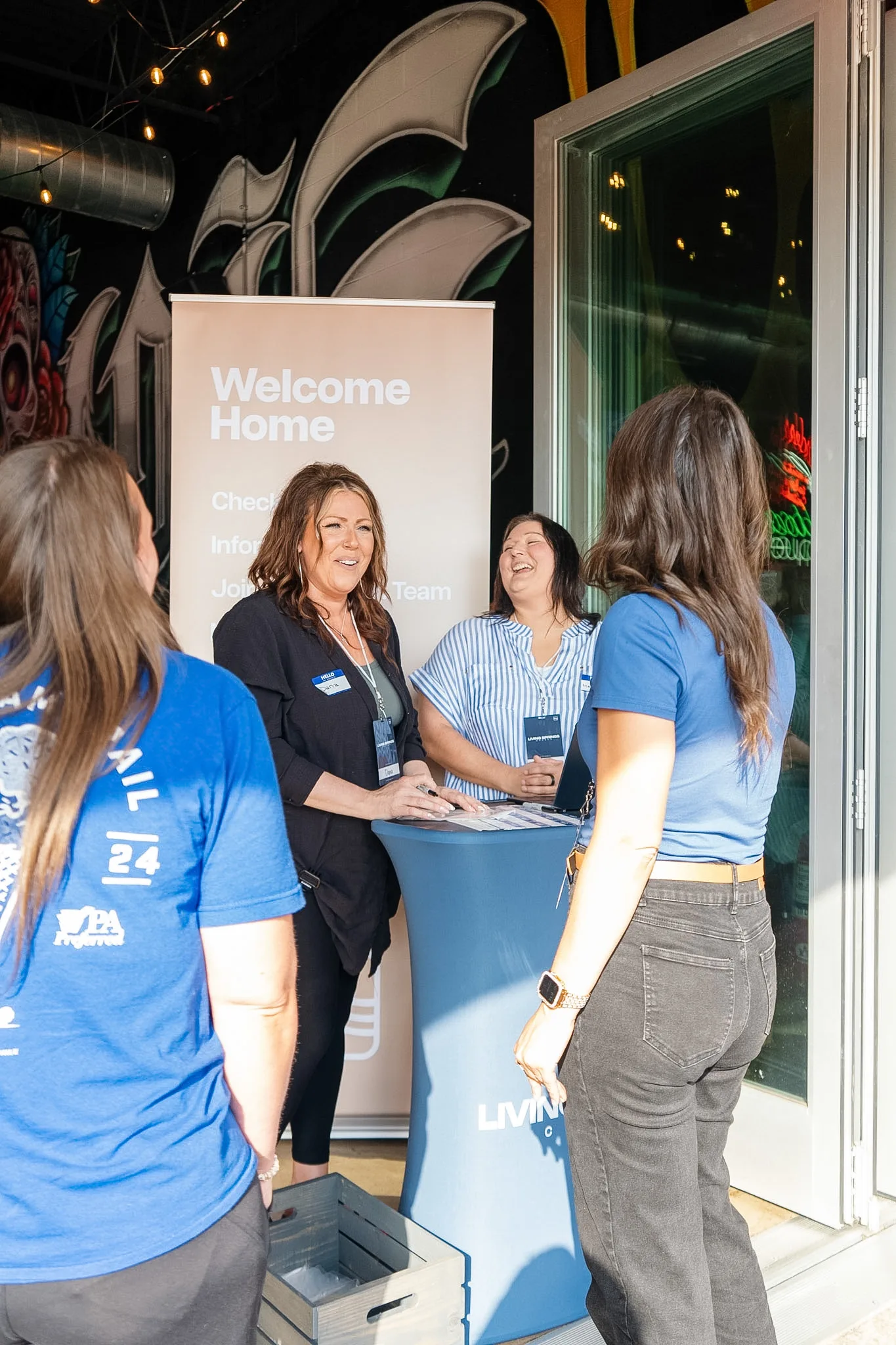 Dream Team volunteers welcoming guests at the Welcome Home table