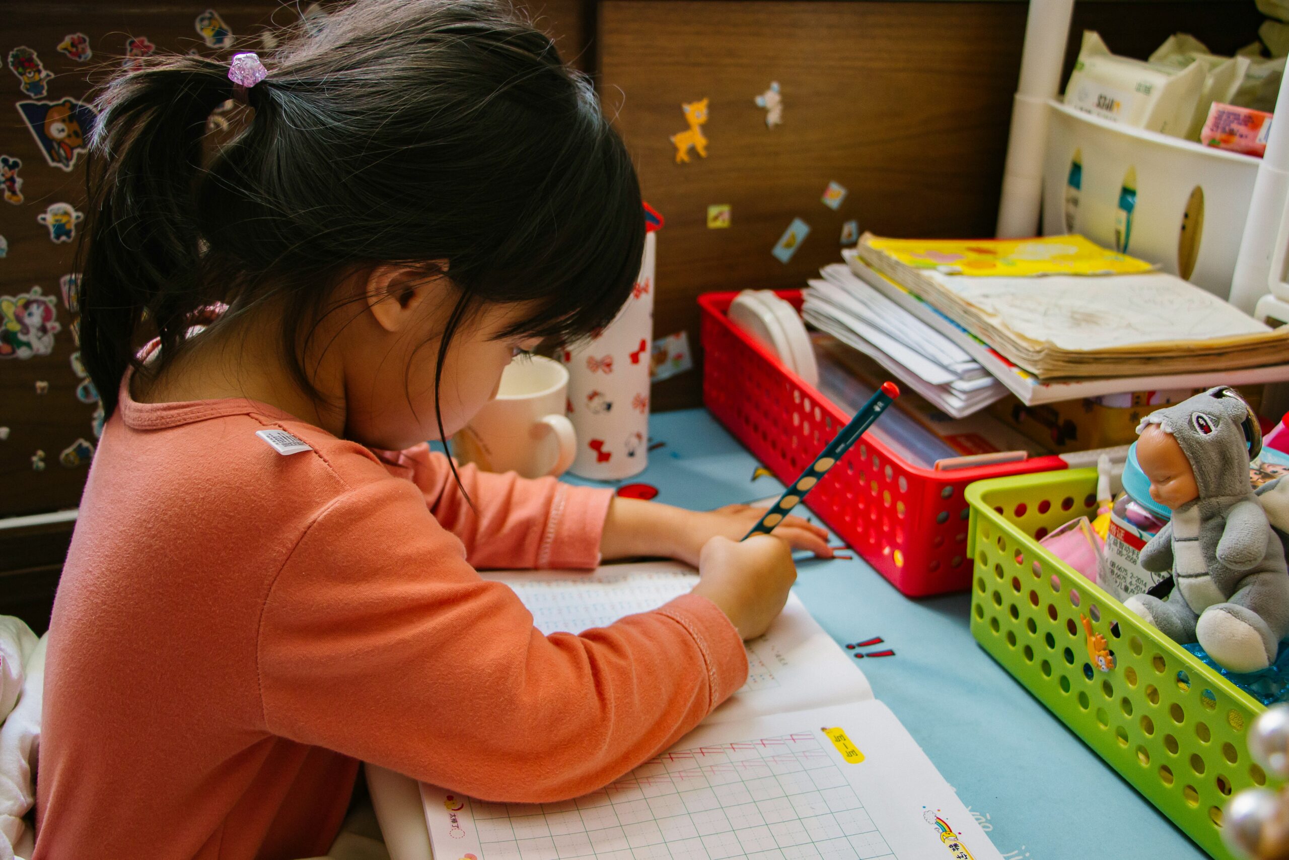A woman with two children at a table with coloring and toys